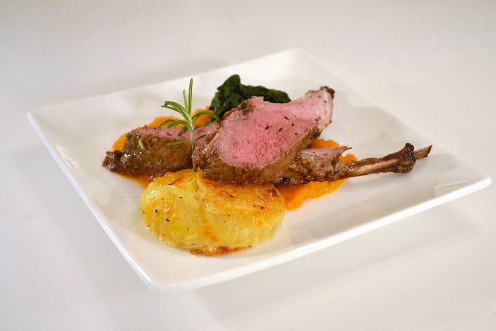 Sizzling pan-seared spiced lamb chops basted in garlic herb butter in a cast iron skillet