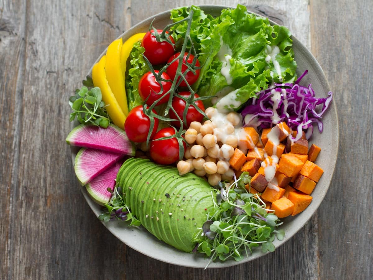 Vibrant Mediterranean chickpea chopped salad with Persian cucumbers, cherry tomatoes, kalamata olives, bell peppers, and creamy herb feta dressing
