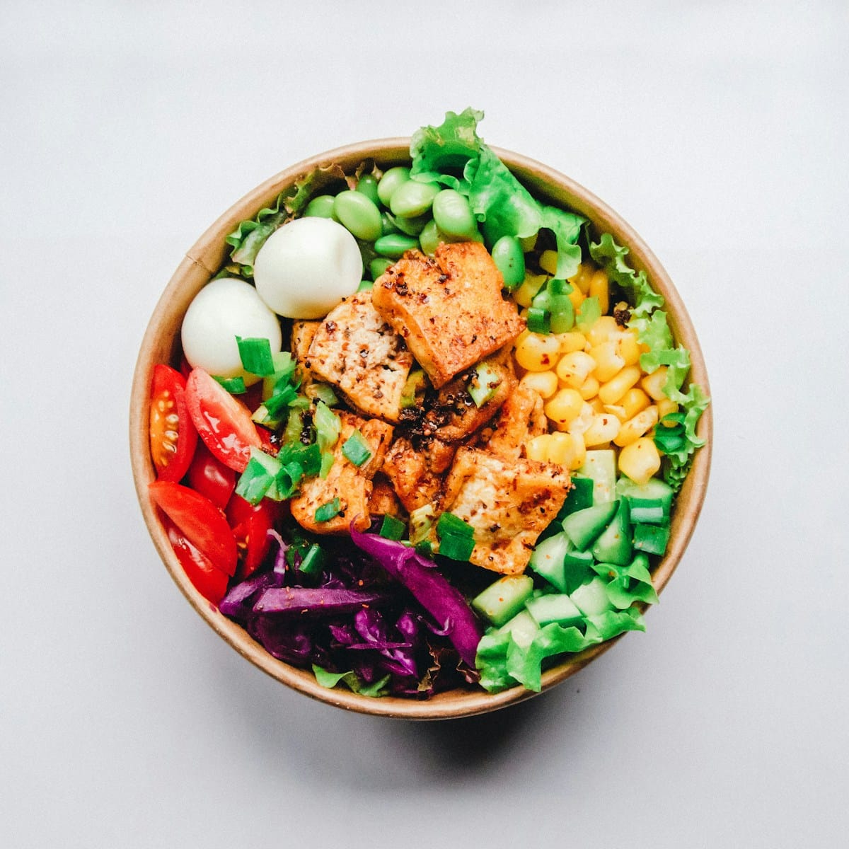 Vibrant bowl of browned spicy ground turkey, steamed green edamame, sliced scallions, and toasted sesame seeds