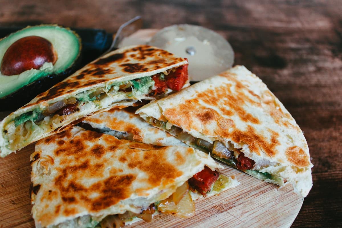 Crispy golden brown quesadilla sliced into triangles showing melted cheese and shredded buffalo chicken filling
