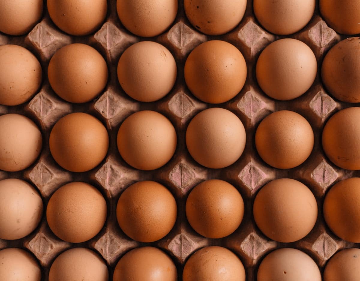 Raw chicken eggs submerged in a clear glass bowl of water undergoing the freshness float test