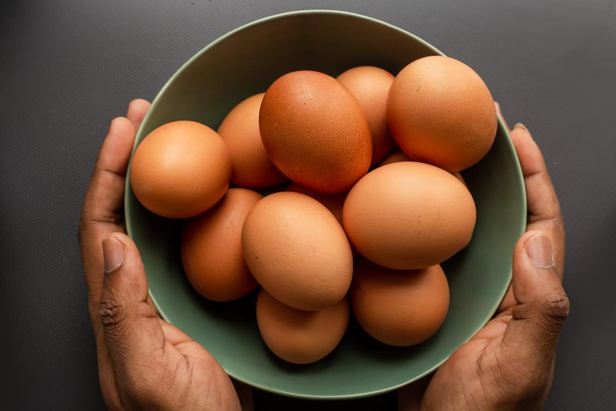 Perfect, smooth, glossy peeled hard-boiled eggs resting on a white ceramic plate