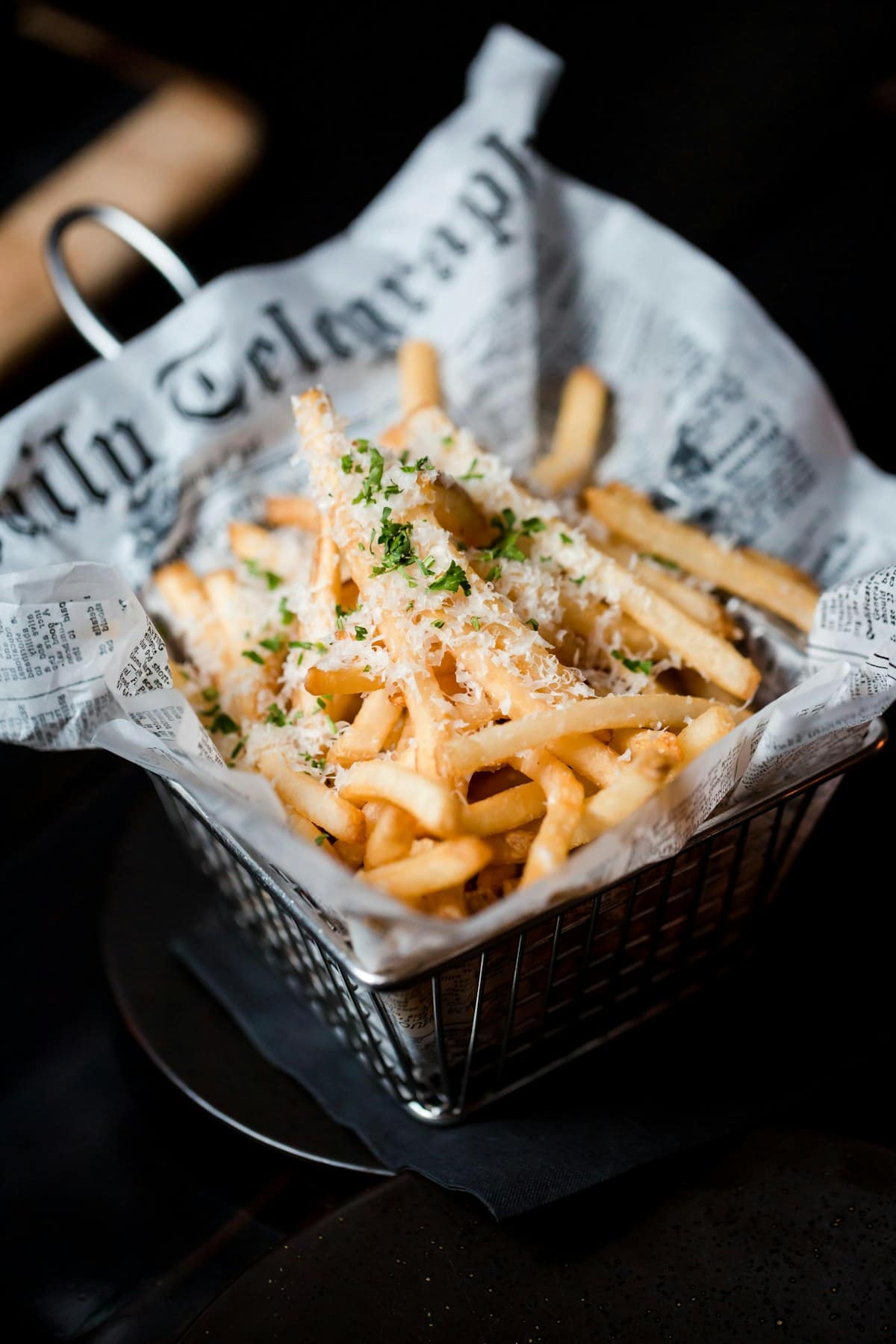 Golden brown, crispy reheated french fries sprinkled with sea salt in a wire basket