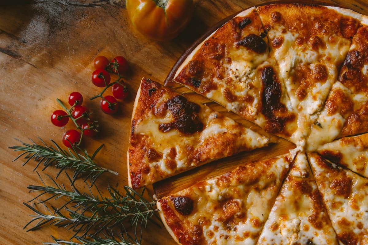 A slice of pizza being reheated in a cast-iron skillet with bubbling melted cheese
